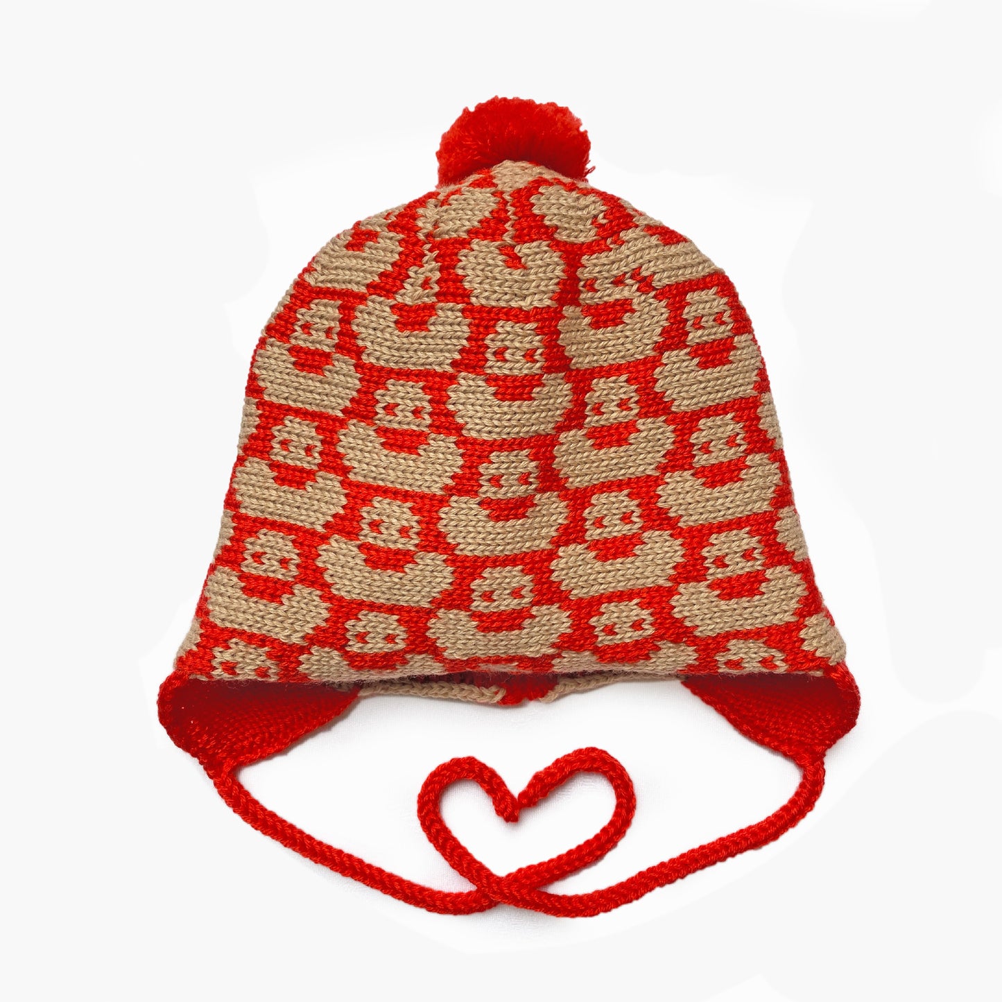 Orangerot/Beige Mütze für Babies und Kinder mit einem fortlaufenden Muster mit kleinen Enten. Die Babymütze hat eine Bommel und angestrickte Ohrläppchen mit Bändern zum festbinden. Sie ist aufwendig der Kopfform nachgestrickt und paßt sich sehr gut an. Das rote Label mit der kleinen Ente ist hinten angenäht.