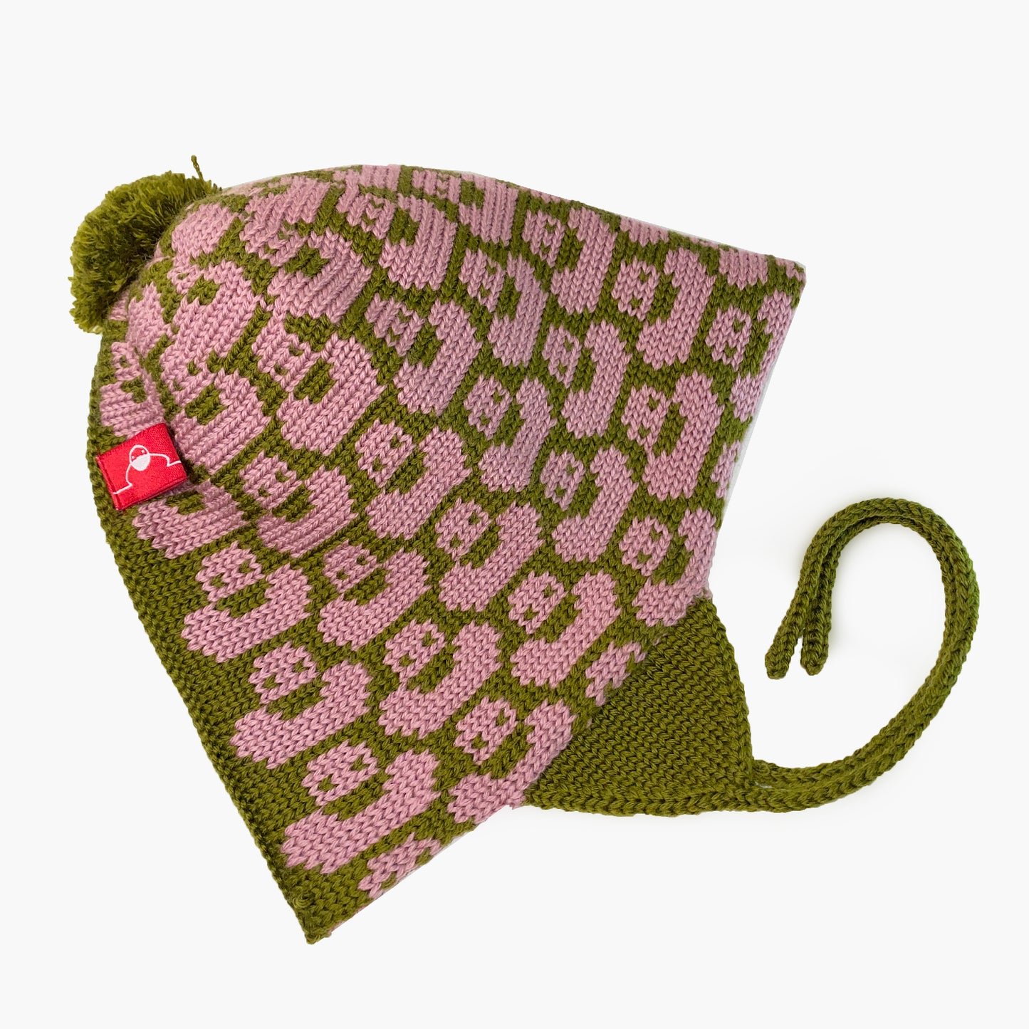 Olivegrün/Rosenholtfarbene Mütze für Babies und Kinder mit einem fortlaufenden Muster mit kleinen Enten. Die Babymütze hat eine Bommel und angestrickte Ohrläppchen mit Bändern zum festbinden. Sie ist aufwendig der Kopfform nachgestrickt und paßt sich sehr gut an. Das rote Label mit der kleinen Ente ist hinten angenäht.