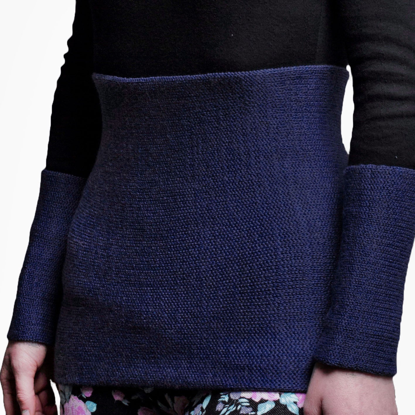 eine Frau ist von Vorne zu sehen im Bereich unter der Brust bis zu den Oberschenkeln. Sie trägt einen Nierenwärmer um den Bauch und an den Handgelenken Armstulpen alles in Royalblau.