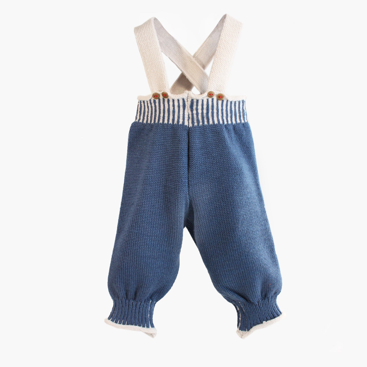 Woll-Hose, Salopette aus Bio-Merinowolle von vincente gestrickt. Sie ist Jeans-Blau mit Woll-weißen Hosenträgern und Woll-weißen Streifen im enganliegenden Bündchen. Die Knöpfe sind Beige und mit Roten Garn angenäht