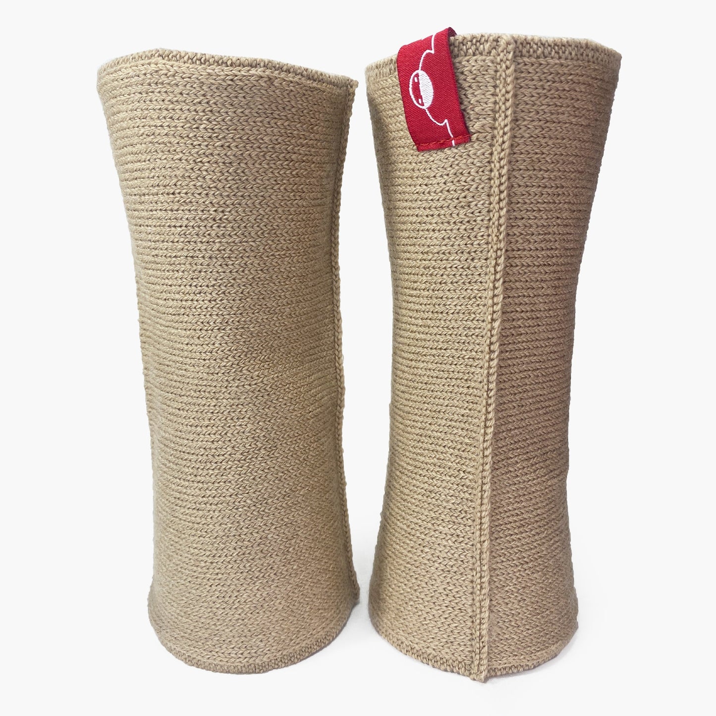 Beige, aufrecht stehende Armstulpen. Man sieht das außenliegende Glatt Rechts Muster. Innen sind die Stulpen in einem Feinen Knötchenmuster gestrickt, man kann sie auch Innsideout tragen