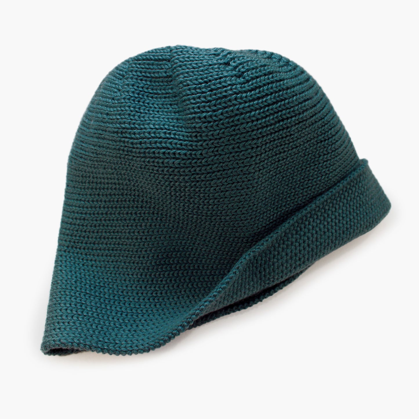 Petrolgrüne Wollmütze aus Merinowolle quer in Kopf-Form gestrickt. Das Fangpatentmuster bedeutet, daß Innen ein Knötchenmuster und außen ein klassiches Rechte Maschenmuster zu sehen ist. Wenn man den Beanie umkrempelt und als Dockermütze trägt ist jeweils das andere Muster zu sehen. Das rote vincente-Label mit der kleinen Ente ist am Rand angenäht. Die Mütze kann insideout getragen werden.
