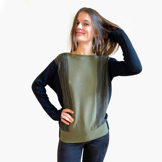 Ein Modell mit braunen langen Haaren trägt einen gestrickten Wollpullover mit Farbverlauf von Olive nach Schwarz