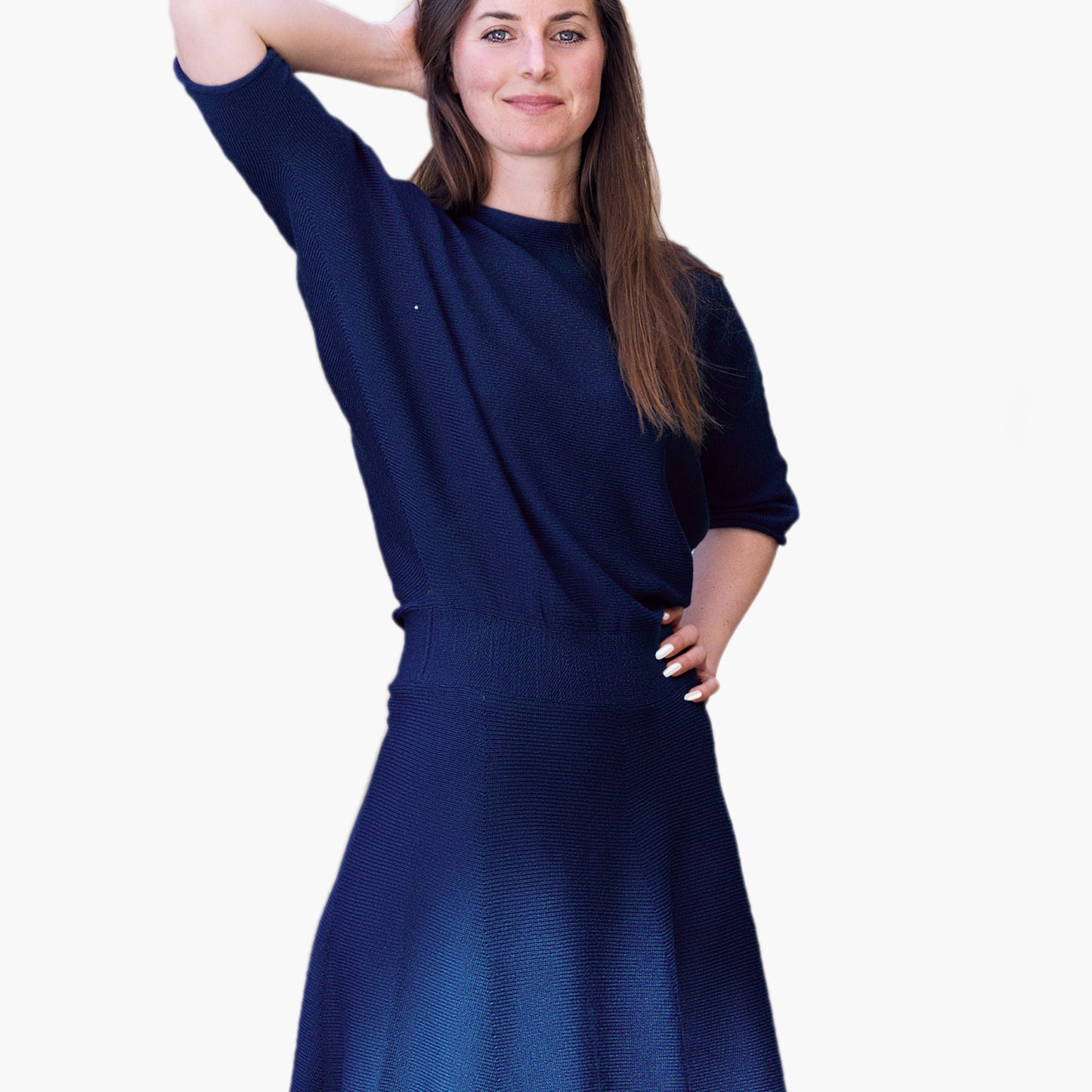 Eine Junge Frau trägt ein Royalblaues, tailliertes Strickkleid mit Fledermausärmeln 3/4lang und ausgestellten Rock.