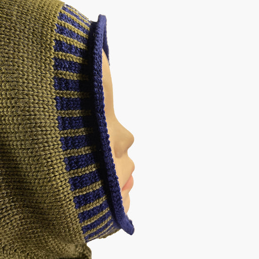 Olivegrüne, gestrickte Mütze wie eine Sturmhaube. Am Hals und um das Gesicht mit elastischem längsgestreiften Bund in Royalblau.