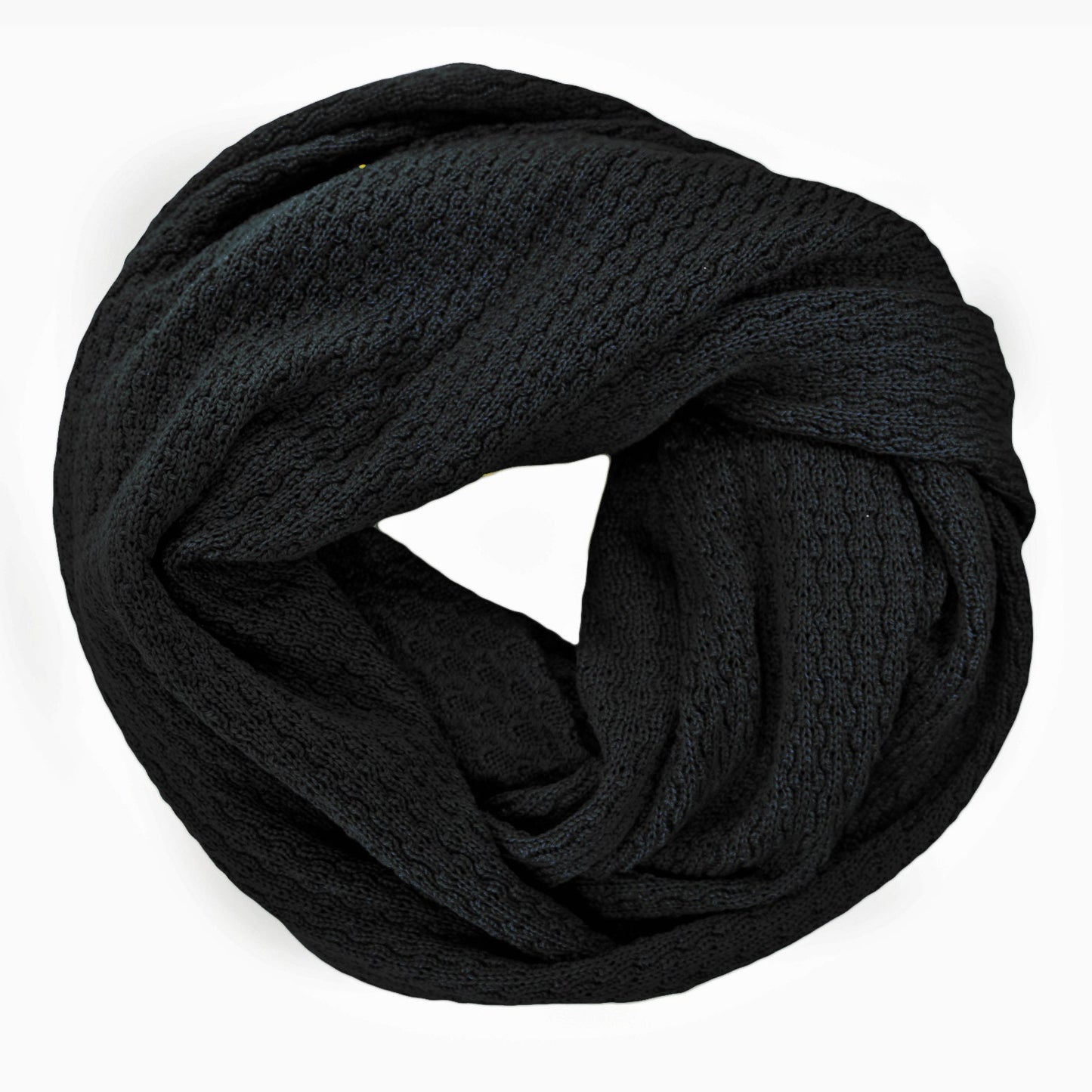 Schwarzer, gestrickter Loop im Fangpatentmuster. Eine Seite sieht glatt rechts mit kleinen Wellen gestrickt aus, die andere Seite sieht aus wie kleine Muscheln. Der Wollschal ist zu einem Haufen drapiert, so sieht man den weichen Fall.