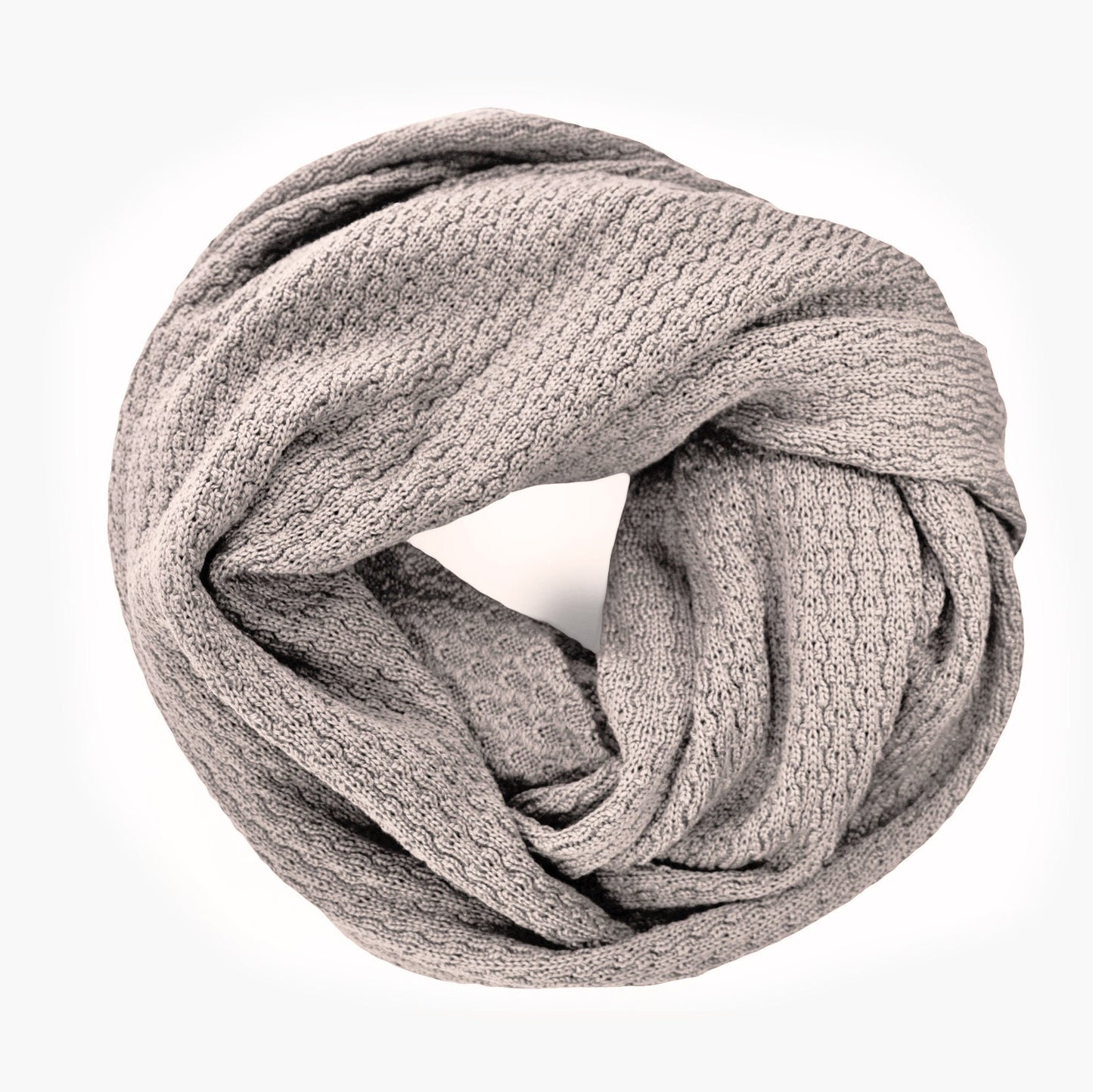 Silbergrauer, gestrickter Loop im Fangpatentmuster. Eine Seite sieht glatt rechts mit kleinen Wellen gestrickt aus, die andere Seite sieht aus wie kleine Muscheln. Der Wollschal ist zu einem Haufen drapiert, so sieht man den weichen Fall.