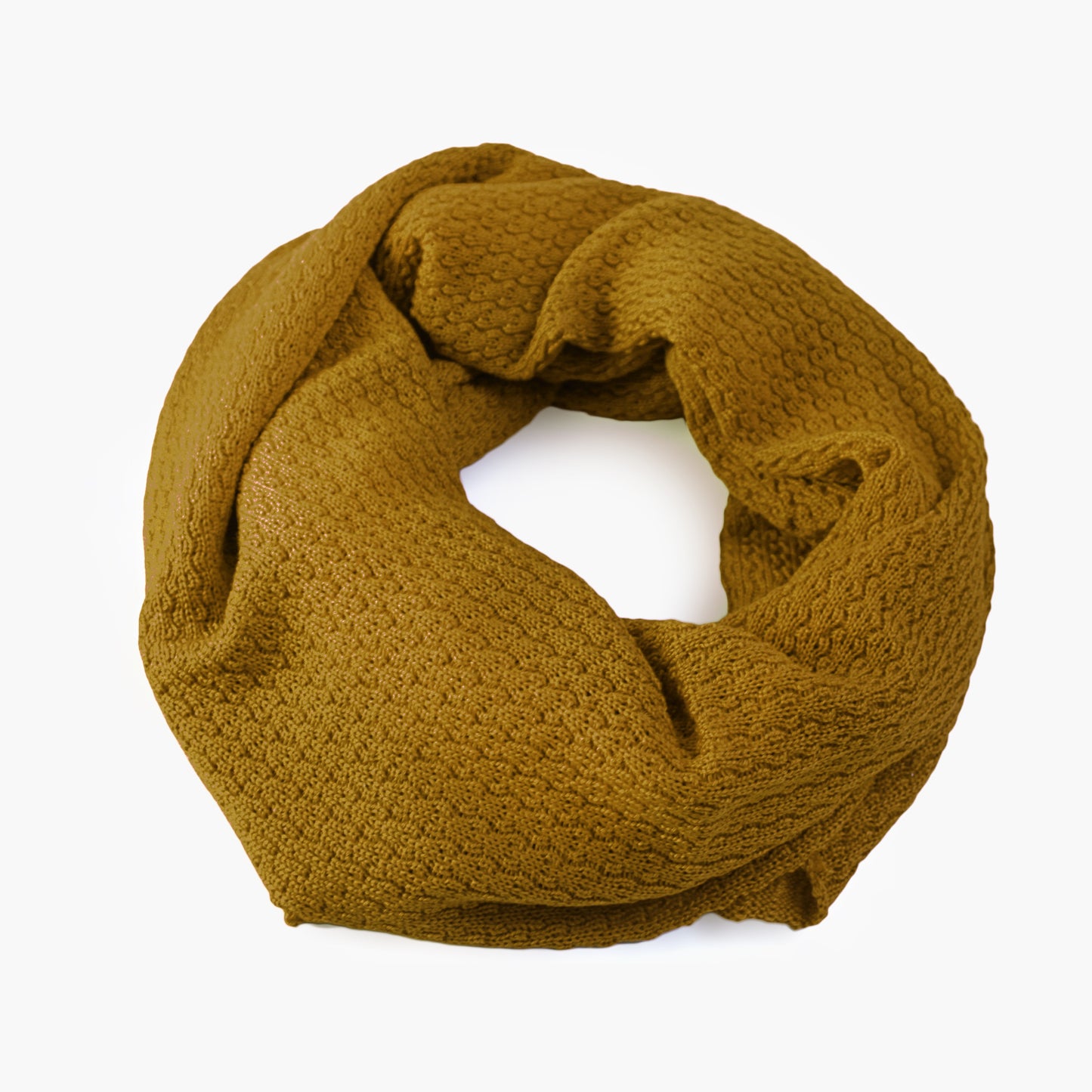 Broncefarbener, gestrickter Loop im Fangpatentmuster. Eine Seite sieht glatt rechts mit kleinen Wellen gestrickt aus, die andere Seite sieht aus wie kleine Muscheln. Der Wollschal ist zu einem Haufen drapiert, so sieht man den weichen Fall.