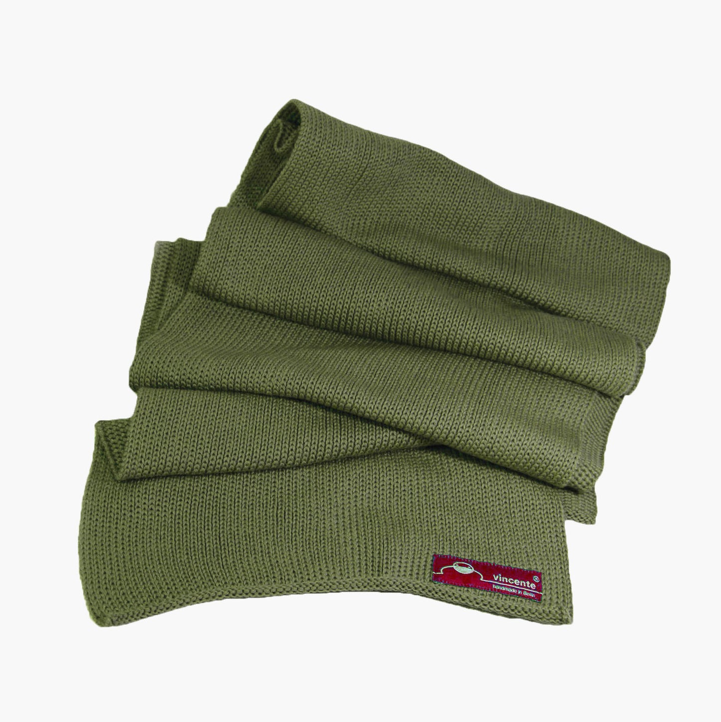 Wald-Grüner, gestrickter Schal im Fangpatentmuster. Eine Seite sieht glatt rechts gestrickt, die andere Seite sieht aus wie minikleine Muscheln oder Punkte. Der Wollschal ist zu einem Haufen drapiert, so sieht man den weichen Fall.