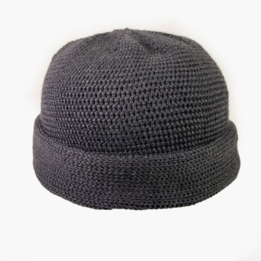 Dunkelgraue Wollmütze aus Merinowolle quer in Kopf-Form gestrickt. Das Fangpatentmuster bedeutet, daß Innen ein Knötchenmuster und außen ein klassiches Rechte Maschenmuster zu sehen ist. Wenn man den Beanie umkrempelt und als Dockermütze trägt ist jeweils das andere Muster zu sehen. Die Mütze kann insideout getragen werden.