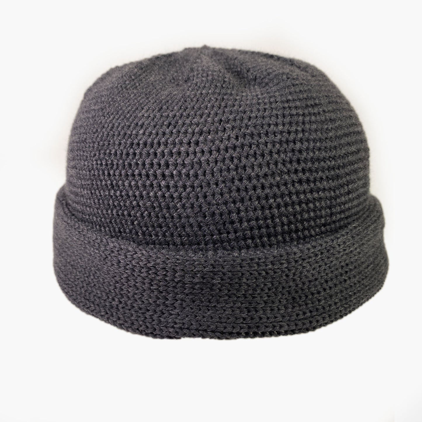 Graue Wollmütze aus Merinowolle quer in Kopf-Form gestrickt. Das Fangpatentmuster bedeutet, daß Innen ein Knötchenmuster und außen ein klassiches Rechte Maschenmuster zu sehen ist. Wenn man den Beanie umkrempelt und als Dockermütze trägt ist jeweils das andere Muster zu sehen. Das rote vincente-Label mit der kleinen Ente ist am Rand angenäht. Die Mütze kann insideout getragen werden.