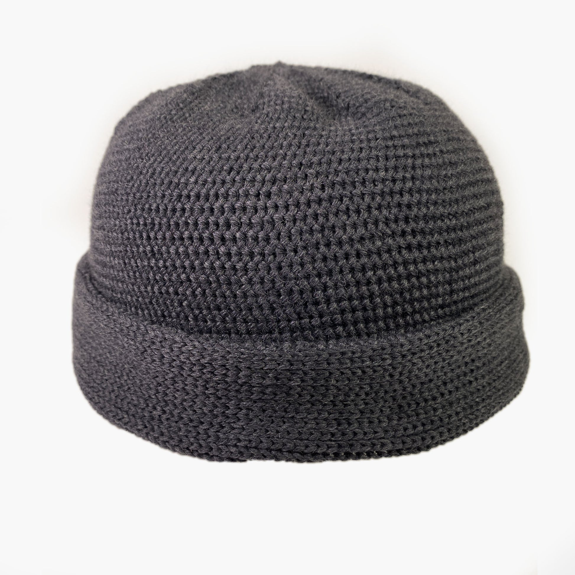 Graue Wollmütze aus Merinowolle quer in Kopf-Form gestrickt. Das Fangpatentmuster bedeutet, daß Innen ein Knötchenmuster und außen ein klassiches Rechte Maschenmuster zu sehen ist. Wenn man den Beanie umkrempelt und als Dockermütze trägt ist jeweils das andere Muster zu sehen. Das rote vincente-Label mit der kleinen Ente ist am Rand angenäht. Die Mütze kann insideout getragen werden.
