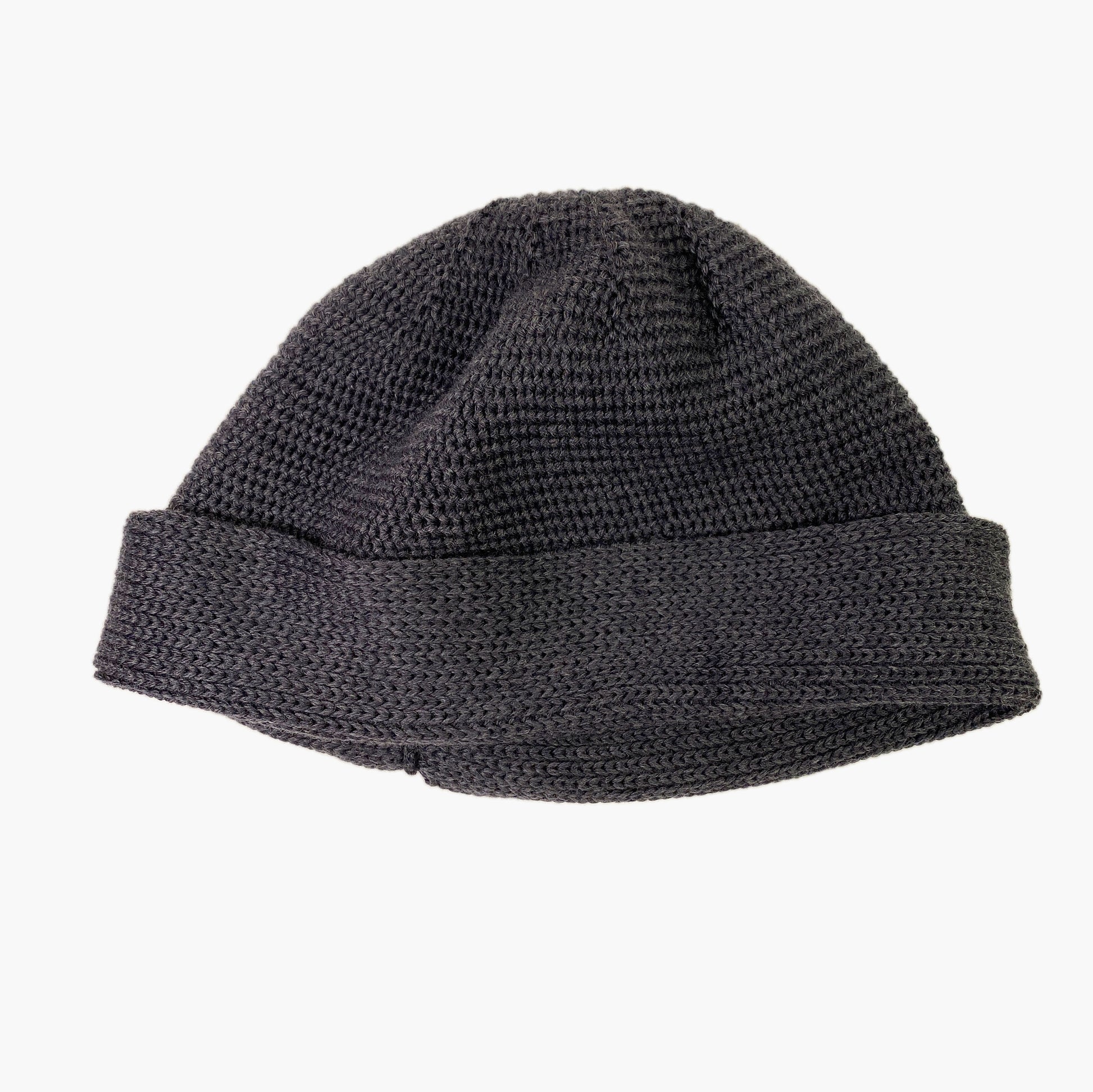Dunkelgraue Wollmütze aus Merinowolle quer in Kopf-Form gestrickt. Das Fangpatentmuster bedeutet, daß Innen ein Knötchenmuster und außen ein klassiches Rechte Maschenmuster zu sehen ist. Wenn man den Beanie umkrempelt und als Dockermütze trägt ist jeweils das andere Muster zu sehen. Das rote vincente-Label mit der kleinen Ente ist am Rand angenäht. Die Mütze kann insideout getragen werden.