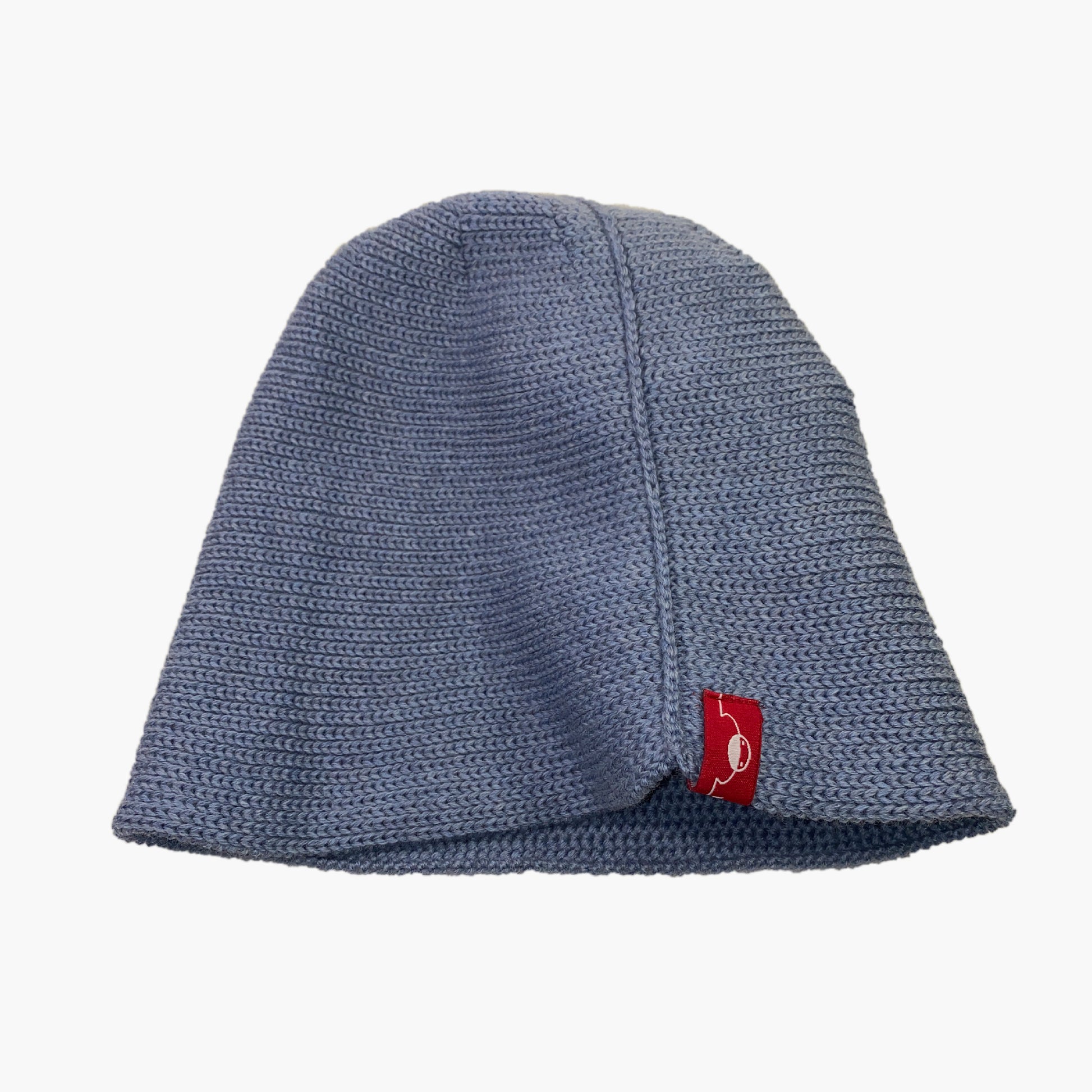 Graublaue Wollmütze aus Merinowolle quer in Kopf-Form gestrickt. Das Fangpatentmuster bedeutet, daß Innen ein Knötchenmuster und außen ein klassiches Rechte Maschenmuster zu sehen ist. Wenn man den Beanie umkrempelt und als Dockermütze trägt ist jeweils das andere Muster zu sehen. Das rote vincente-Label mit der kleinen Ente ist am Rand angenäht. Die Mütze kann insideout getragen werden.