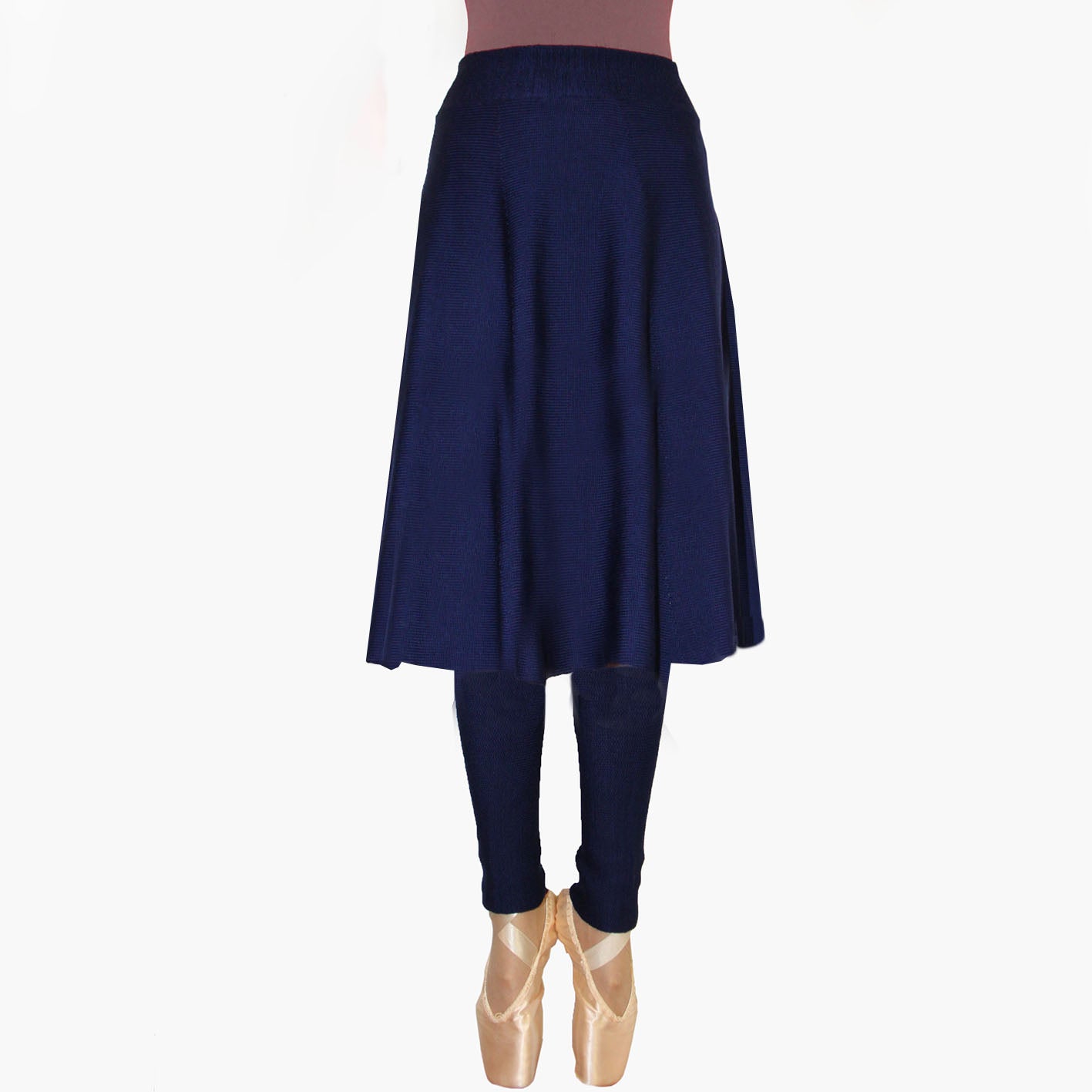 Man sieht ein Model vom Bauchnabel abwärts in einem ausgestellten  Strickrock in Royalblau, der bis zu den Waden reicht. Sie trägt sammetrote Schuhe mit hohen Absätzen.
