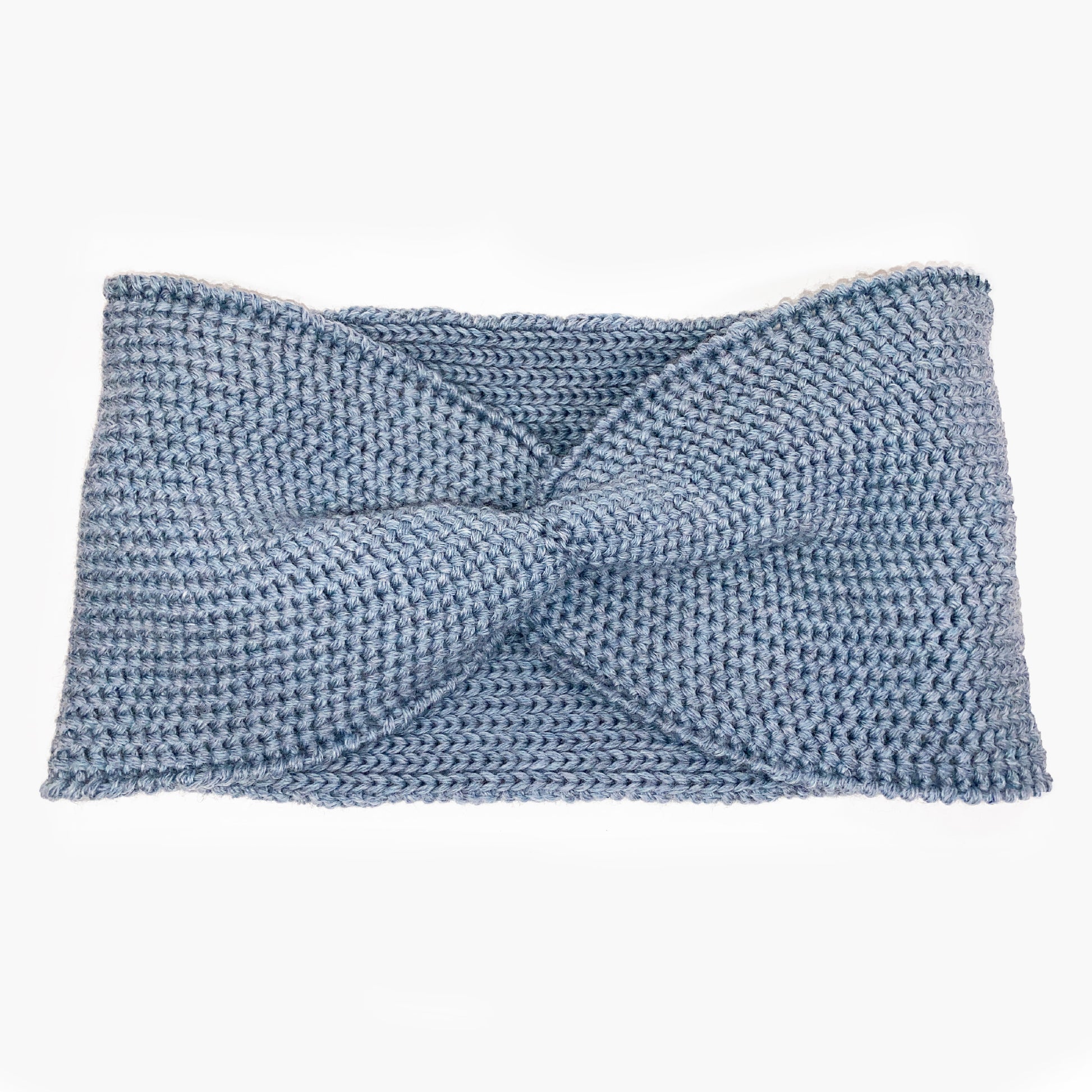 Graublaues Stirnband mit einer Turban-ähnlichen Verdrehung. Gestrickt im  Doubleface Patentmuster, außen Knötchenstruktur und Innen sieht es wie ein klassisch rechts gestricktes Muster aus.