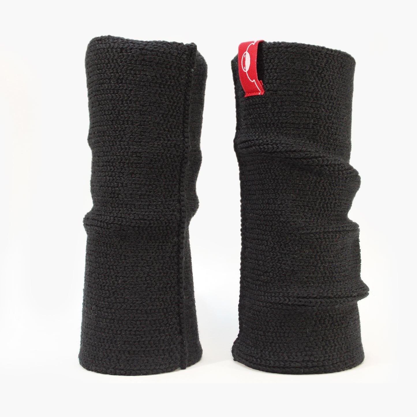 Schwarze aufrecht stehende Armstulpen. Man sieht das außenliegende Glatt Rechts Muster. Innen sind die Stulpen in einem Feinen Knötchen-Muster gestrickt, man kann sie auch Innside-out tragen