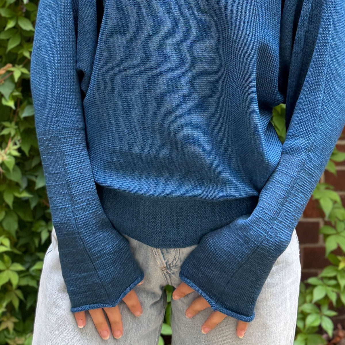 Nahaufnahme der elastischen Bündchen des Designerpullovers aus dem Atelier vincente. man sieht die Weichheit und den leichten Glanz der zertifizierten Merinowolle