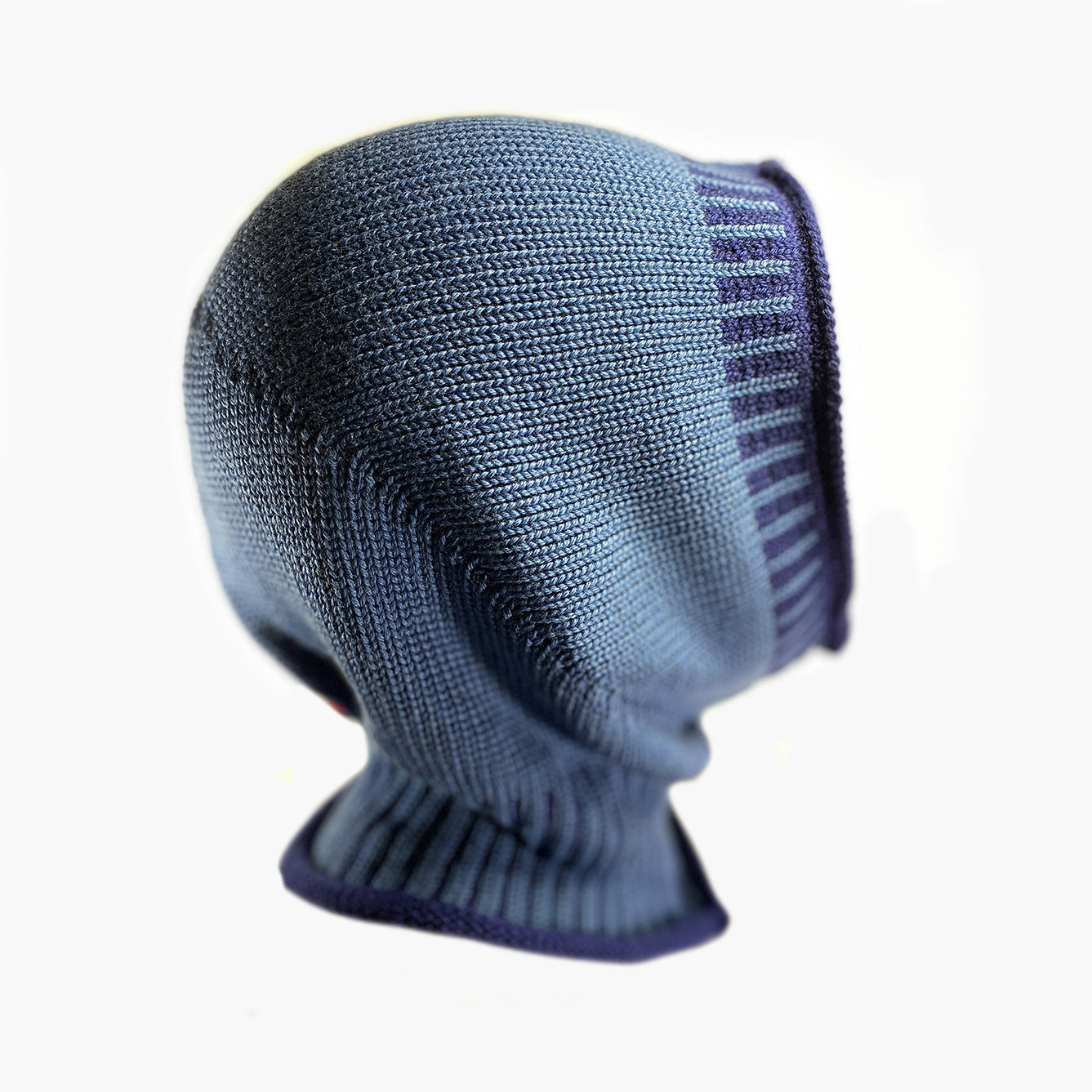 Blaue, gestrickte Mütze wie eine Sturmhaube. Am Hals und um das Gesicht mit elastischem längsgestreiften Bund in Royalblau.