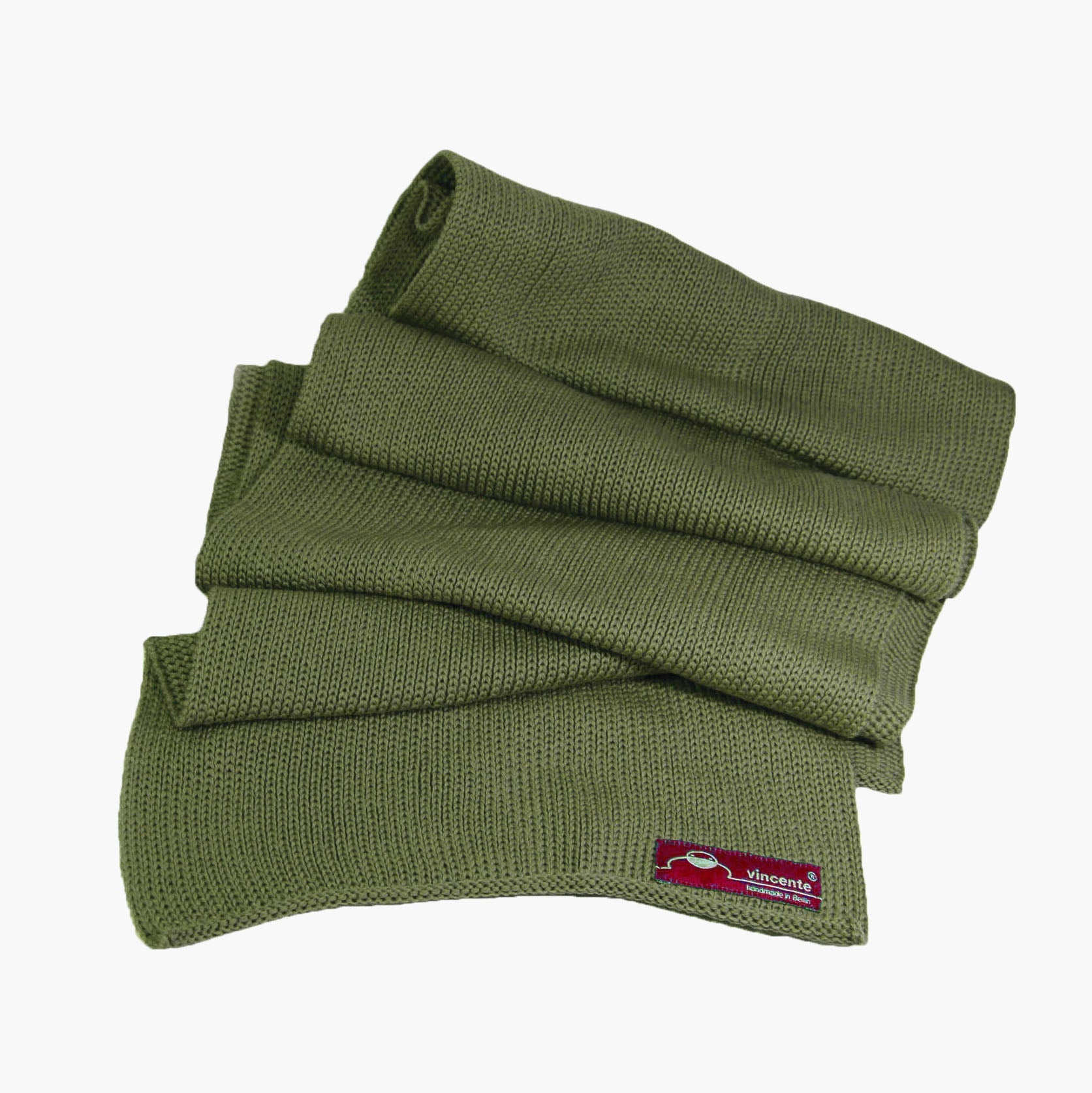 Wald-Grüner, gestrickter Schal im Fangpatentmuster. Eine Seite sieht glatt rechts gestrickt, die andere Seite sieht aus wie minikleine Muscheln oder Punkte. Der Wollschal ist zu einem Haufen drapiert, so sieht man den weichen Fall.