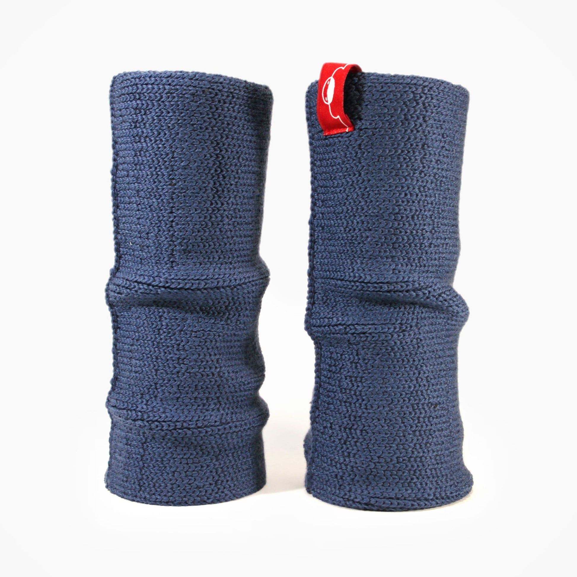 Jeansblaue, aufrecht stehende Armstulpen. Man sieht das außenliegende Glatt Rechts Muster. Innen sind die Stulpen in einem Feinen Knötchenmuster gestrickt, man kann sie auch Innsideout tragen