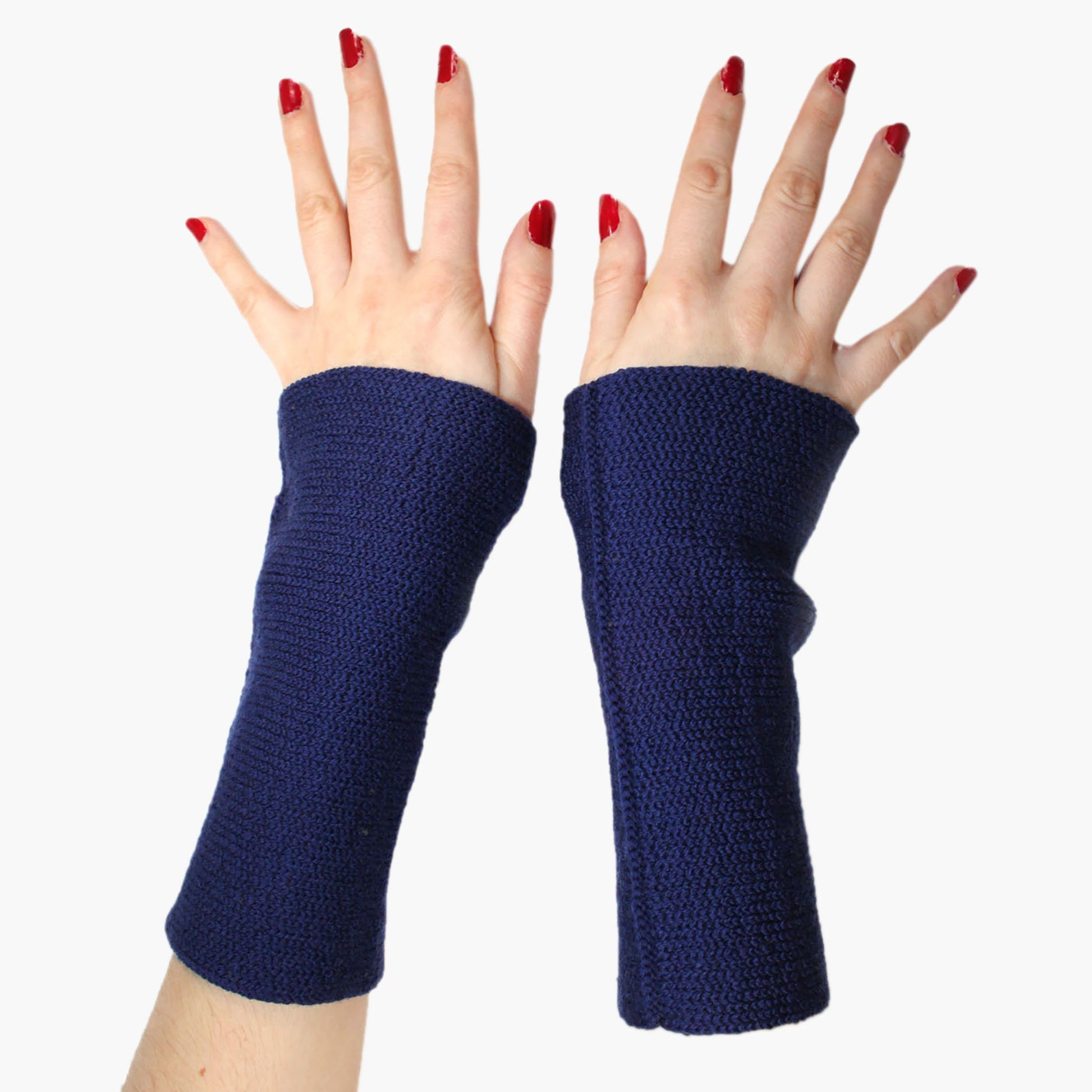 Zwei Hände mit ausgespreizten Fingern und roten Fingernägeln tragen royalblaue Armstulpen.